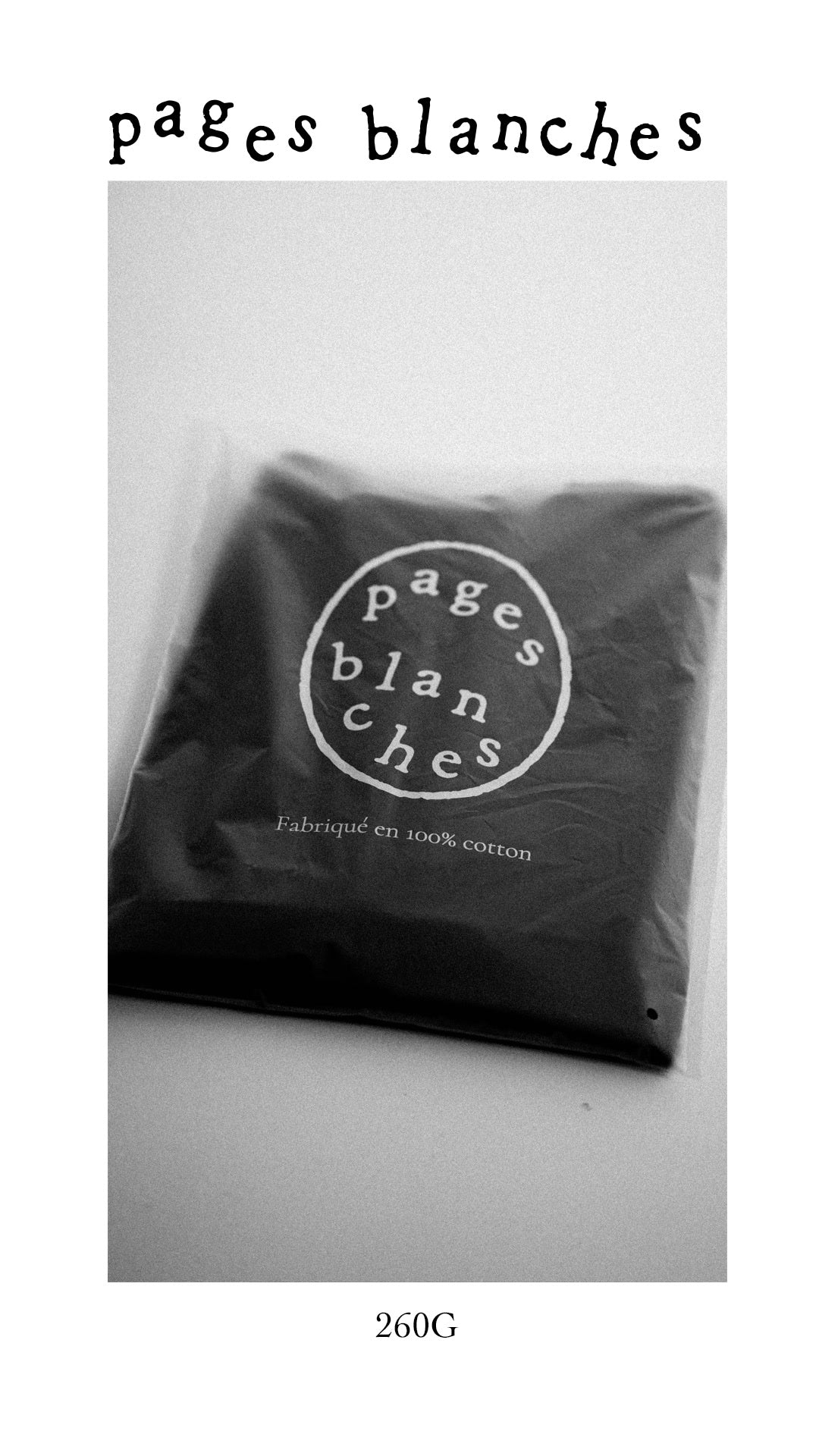 T-shirt noir plié dans sa pochette pages blanches, 260G